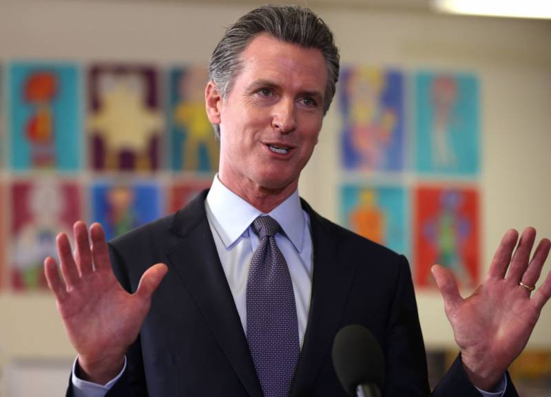 Gov. Gavin Newsom with his hands up.