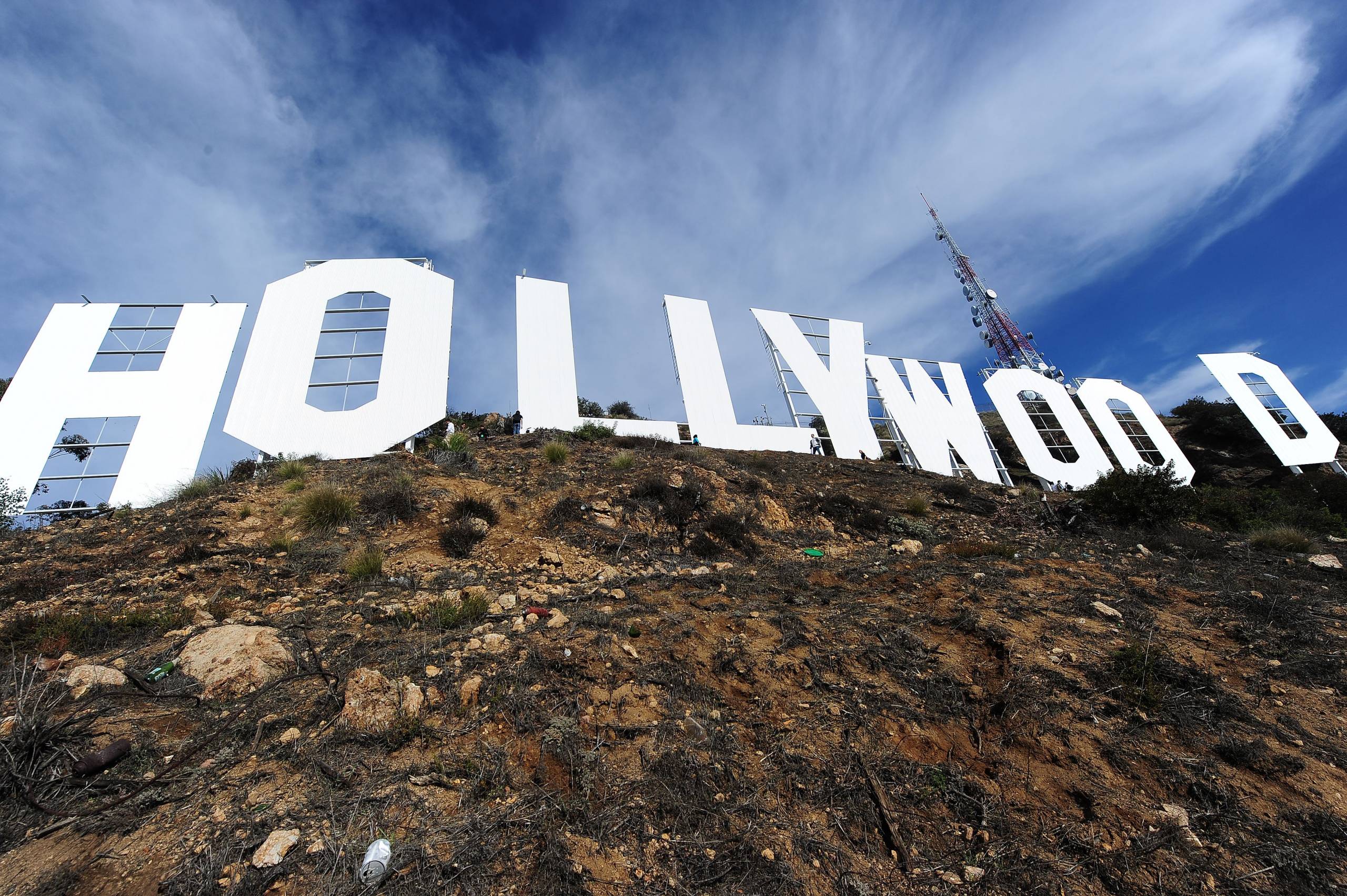 The stories-high, bright-white letters of the Hollywood sign are seen from the ground directly below, filling the entire frame.