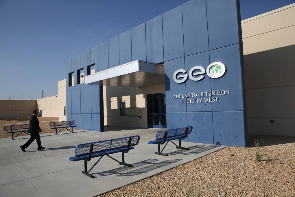 On a modern, low-slung building with no windows, a big sign reading 'GEO' hangs on an exterior wall.