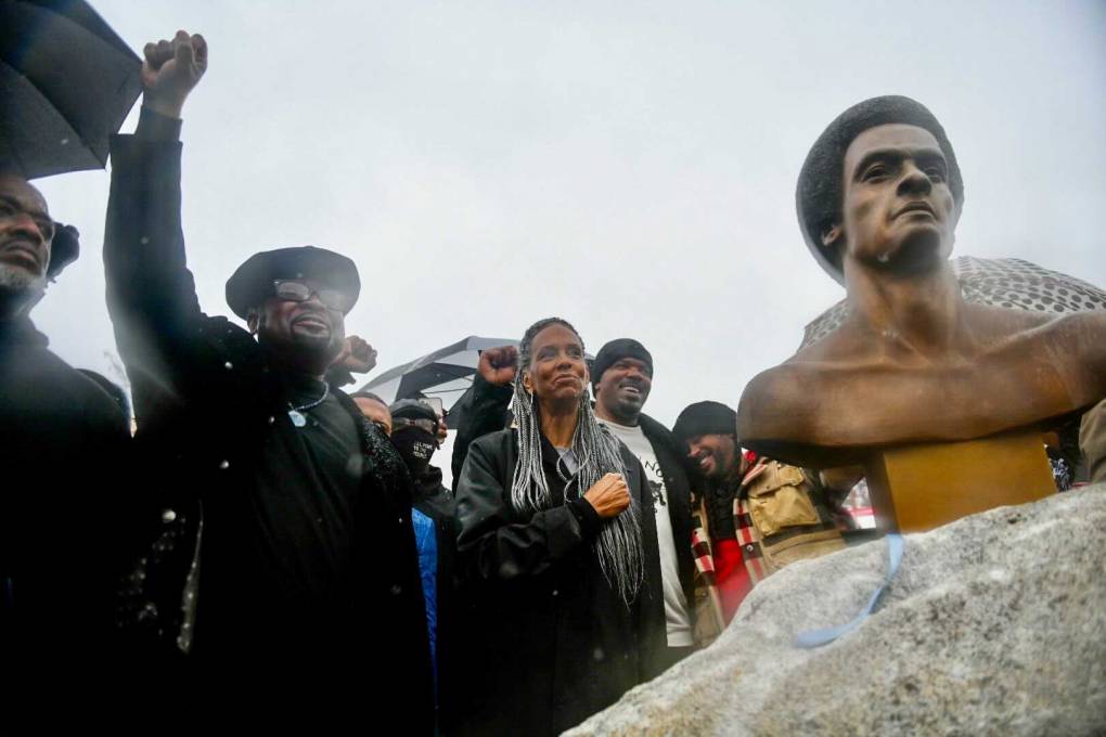 Fred Hampton Jr and Fredrika Newton stand with the bust of Dr. Huey P. Newton
