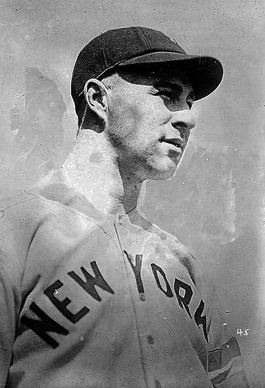 Black and white photo of a man with black baseball cap looking into the distance.
