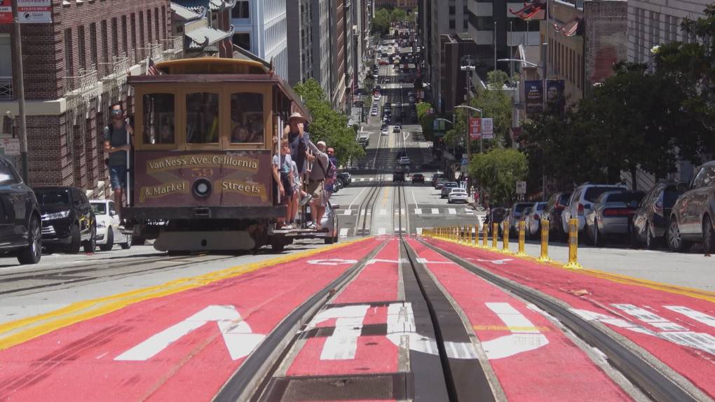 Traditional SF cable car driving up a hill