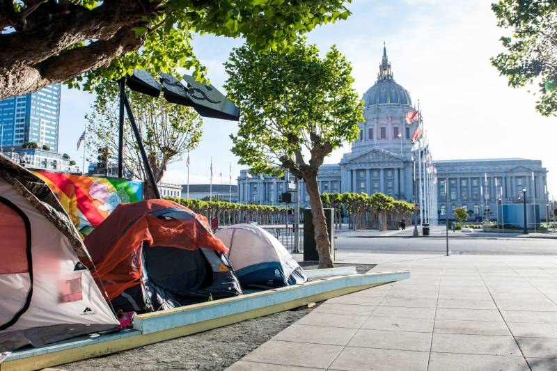 A group of tents on a lawn in front of San Francisco City Hall.