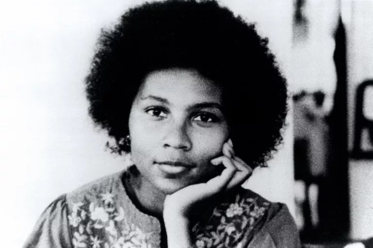 bell hooks looks at the camera straight on and rests her chin on her left palm.