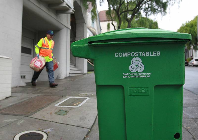 A green trash bin with the word "compostables" is seen on the right with a man wearing a hat