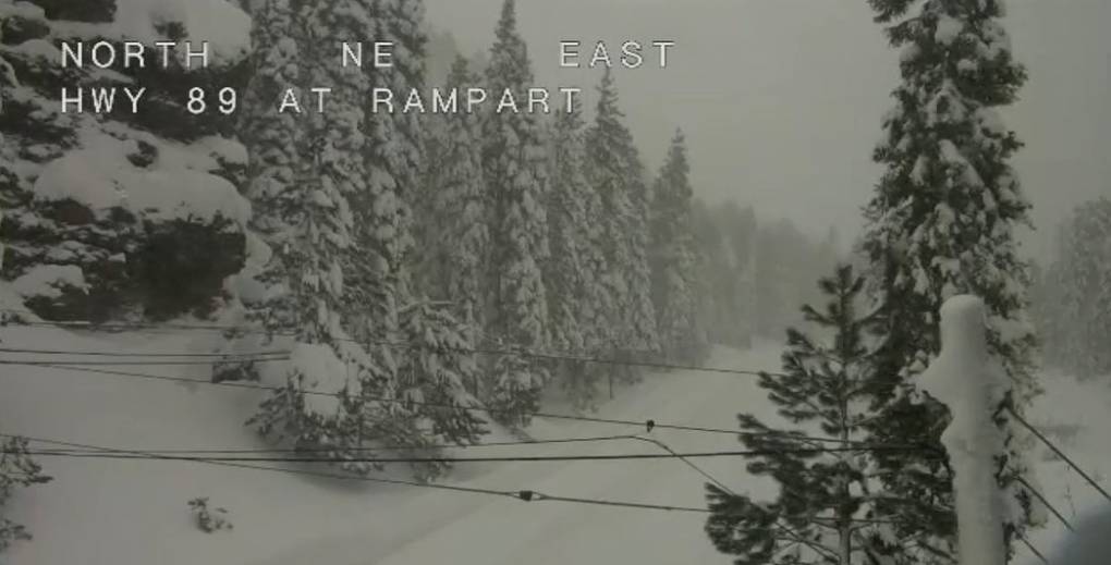 A look at State Route 89 from a webcam, showing it completely covered in snow, with snowy trees along it.