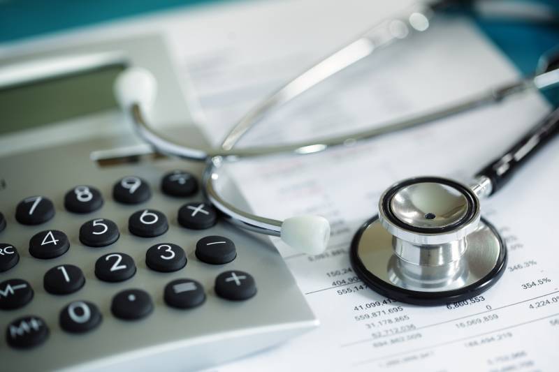 Stethoscope, calculator and medical bills stock image