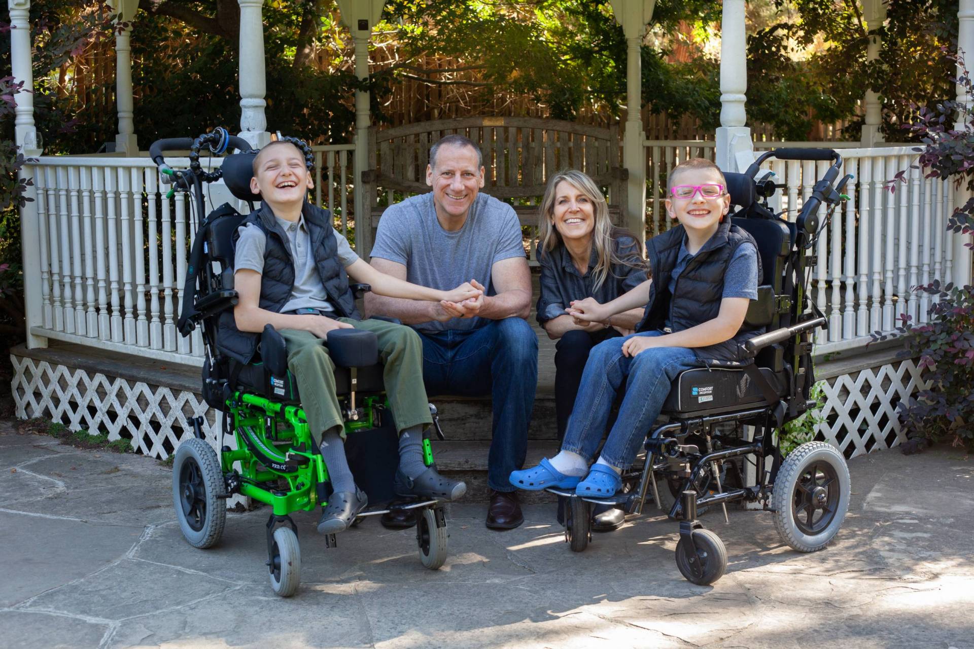 A family of four, with two boys in wheelchairs and a mother and father in the middle.