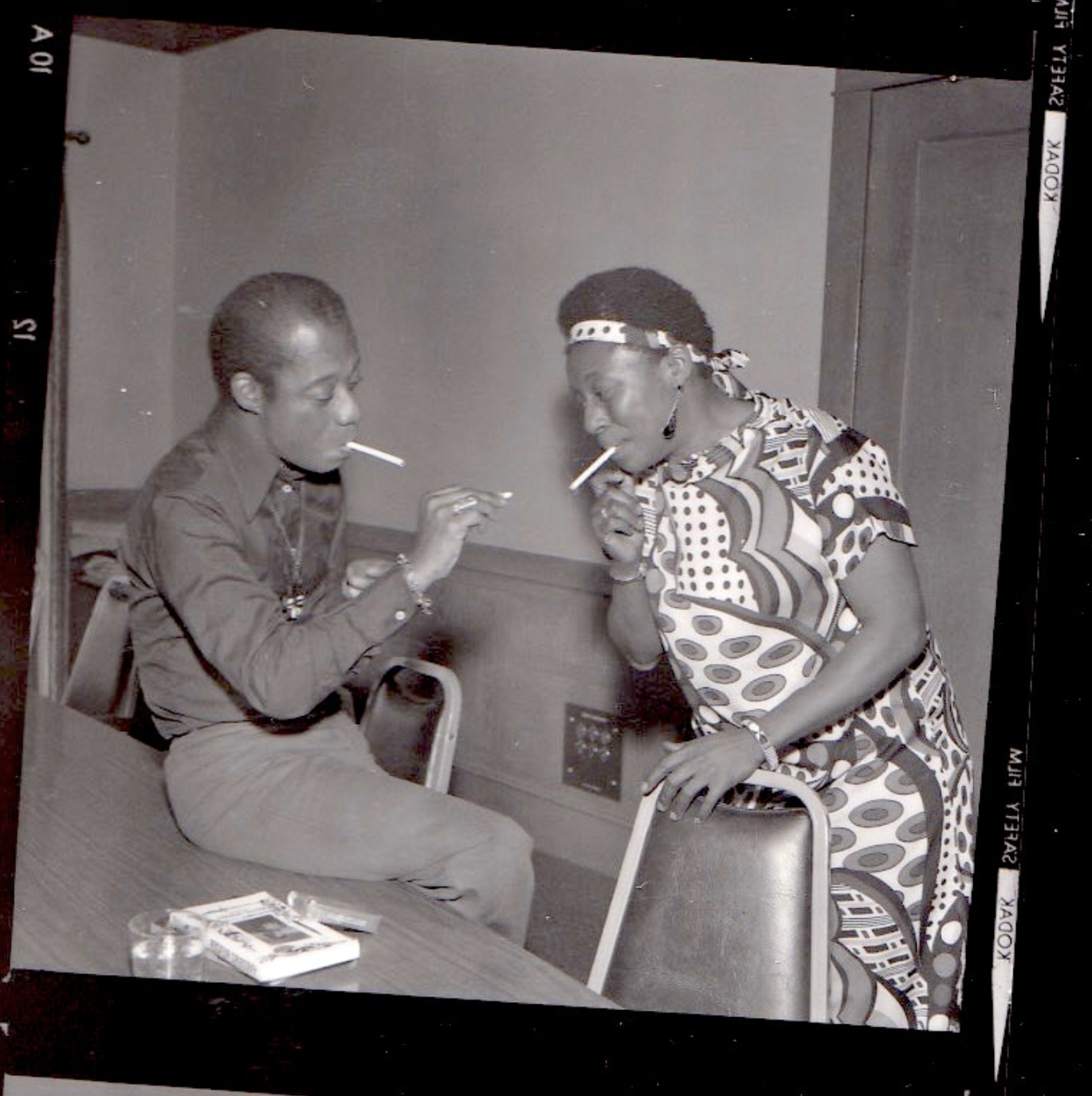 Writer James Baldwin smokes a cigarette with a woman.