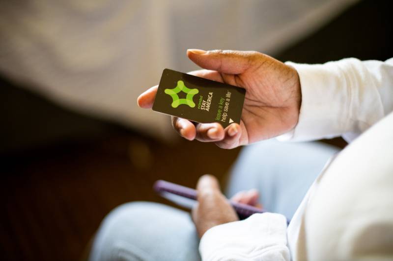A woman holds a room card for the Extended Stay hotel chain.