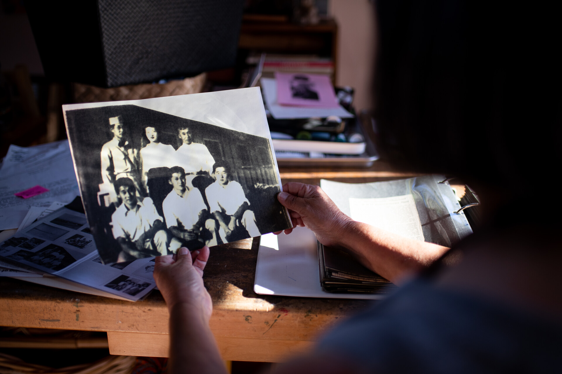 Someone holding a black-and-white photo of a family.