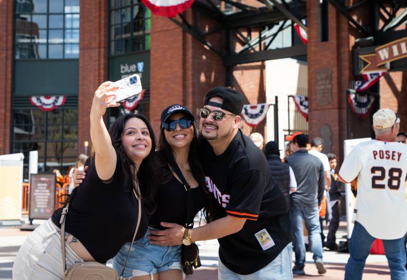3 people pose for a selfie outside giants stadium