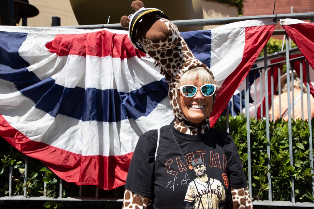 A woman smiles at Giants Opening Day wearing a giraffe hat and a brandon belt Giants T shirt