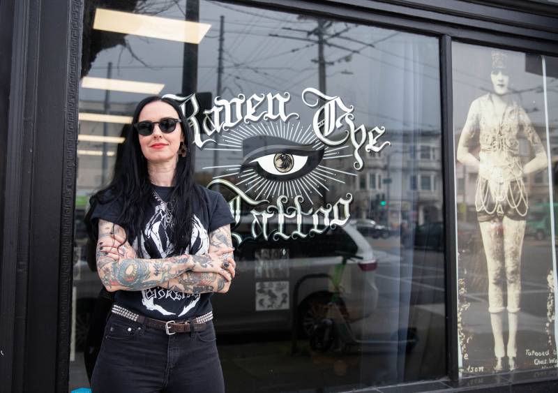 Mary Scott poses in front of Raven Eye Tattoo. 