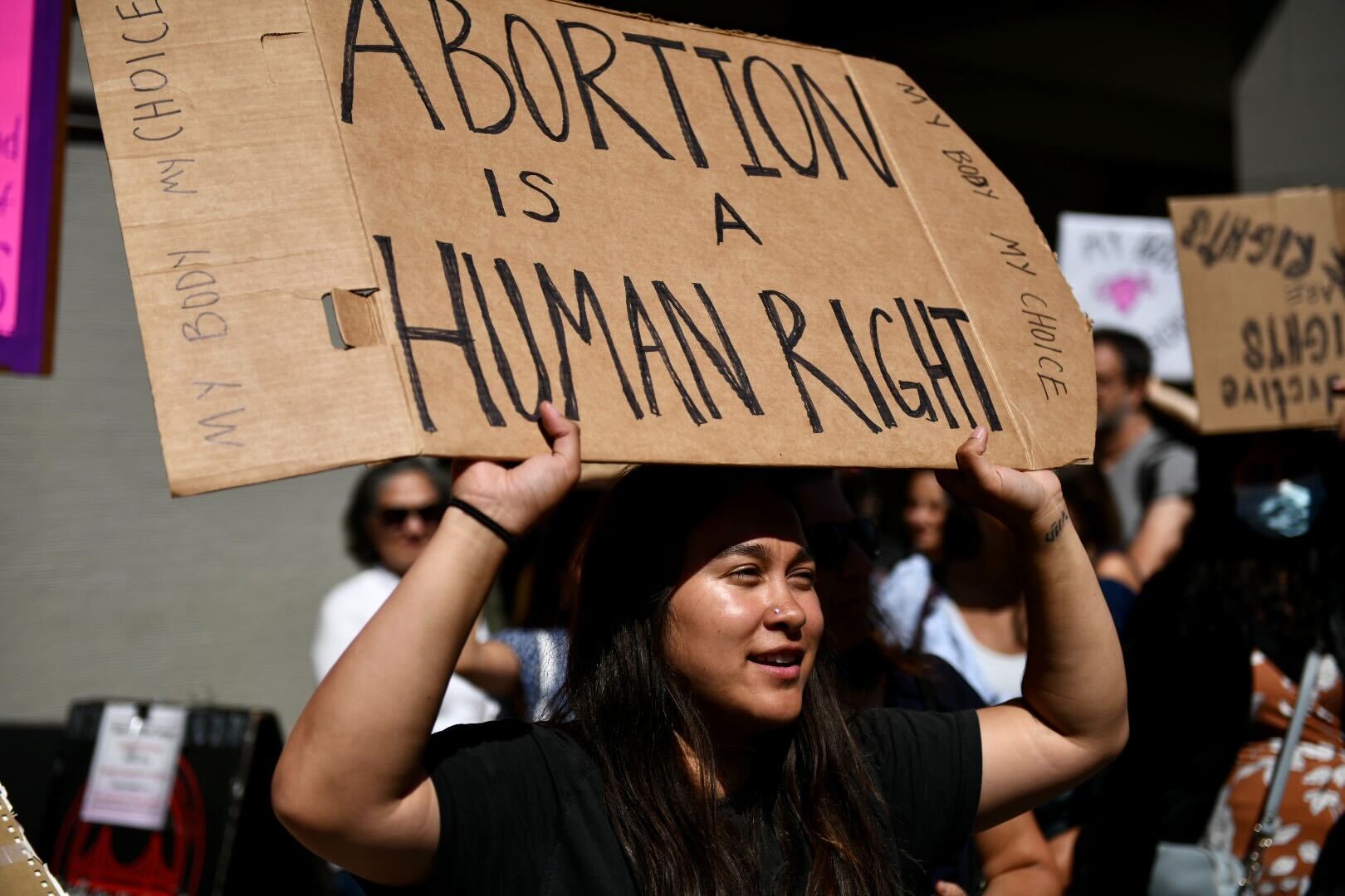 Young person holding up a sign in support of reproductive rights