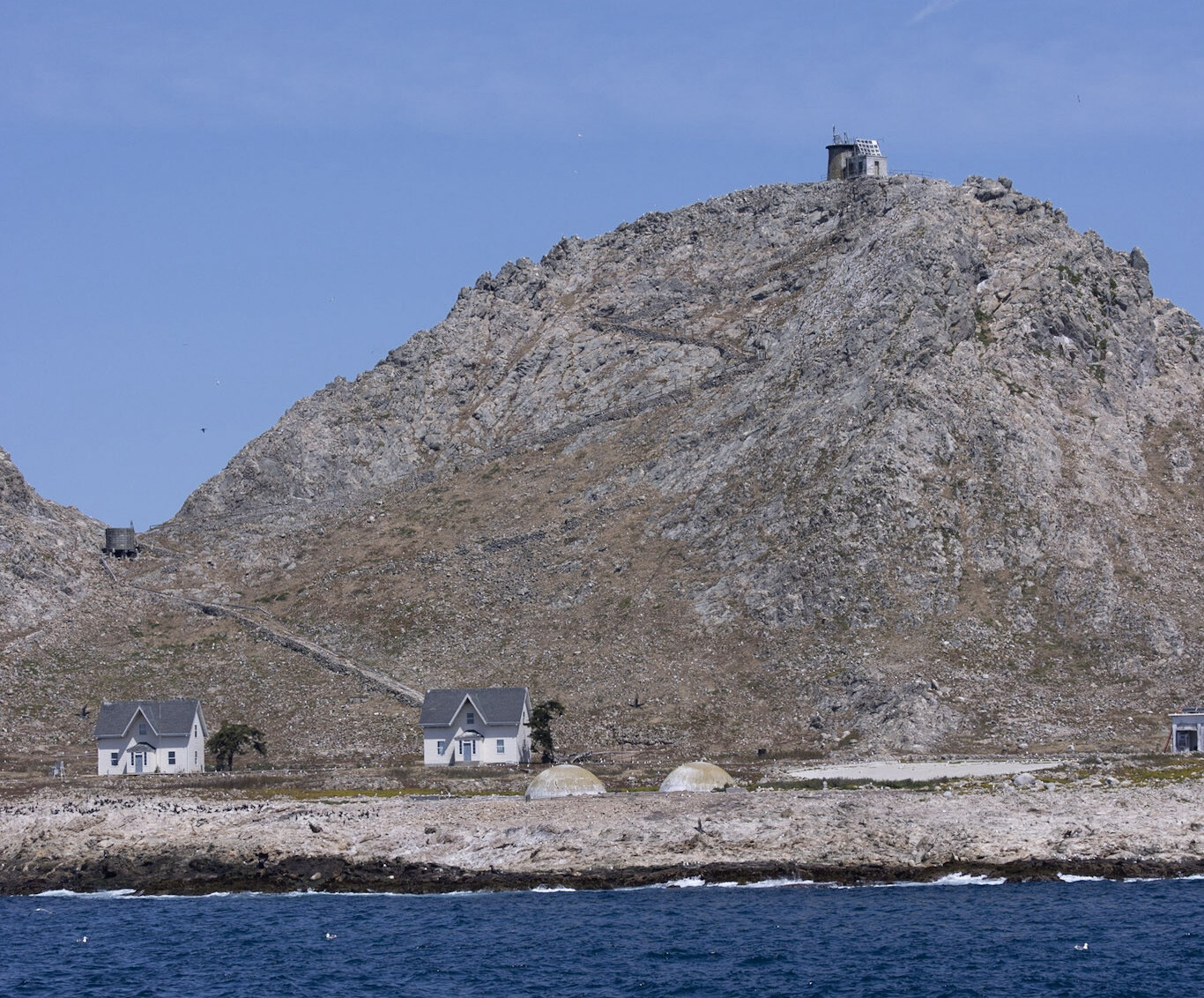 A small cluster of buildings on a rocky island.