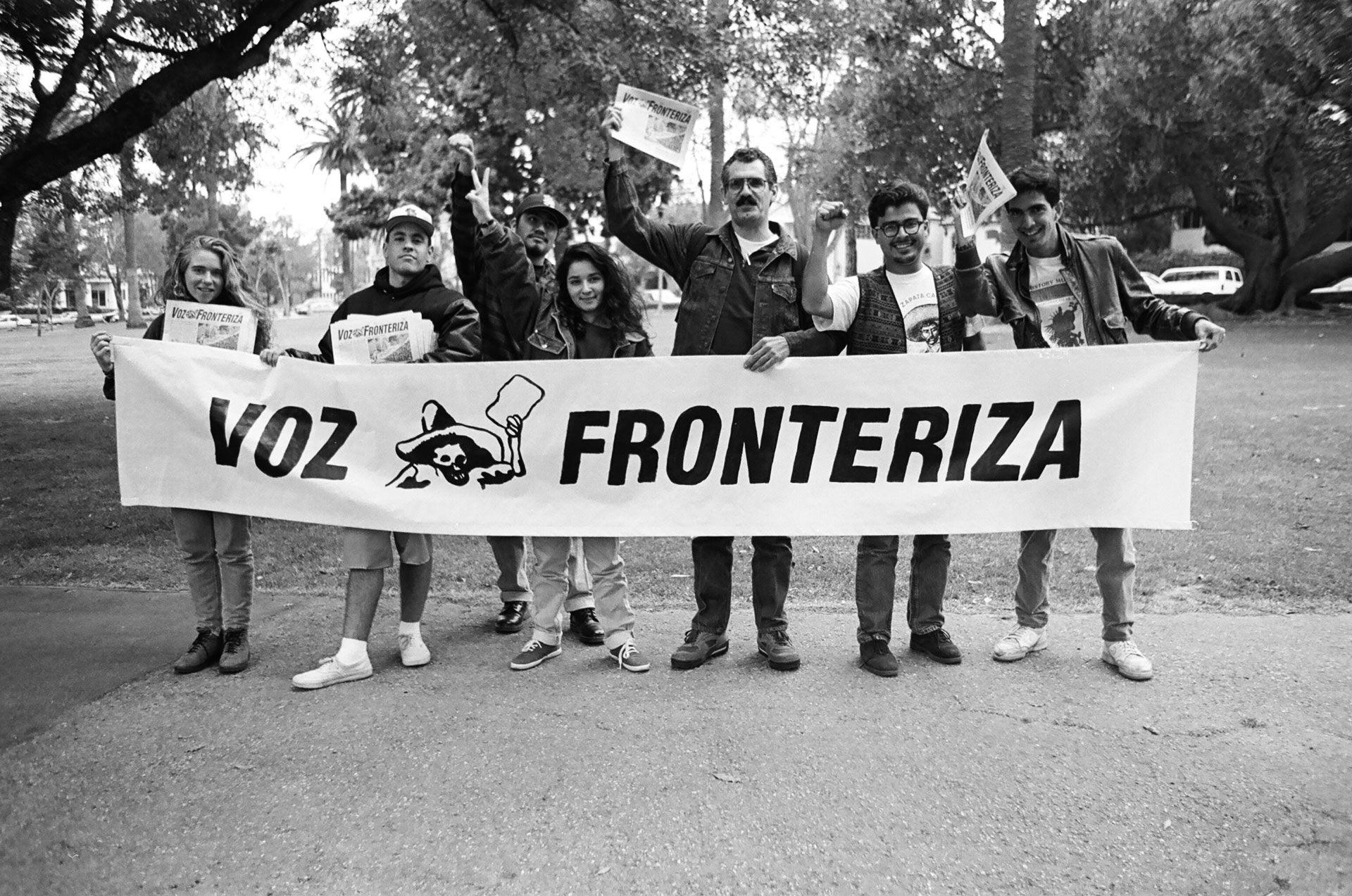 black and white photo of smiling students holding large banner reading 'voz fronteriza'