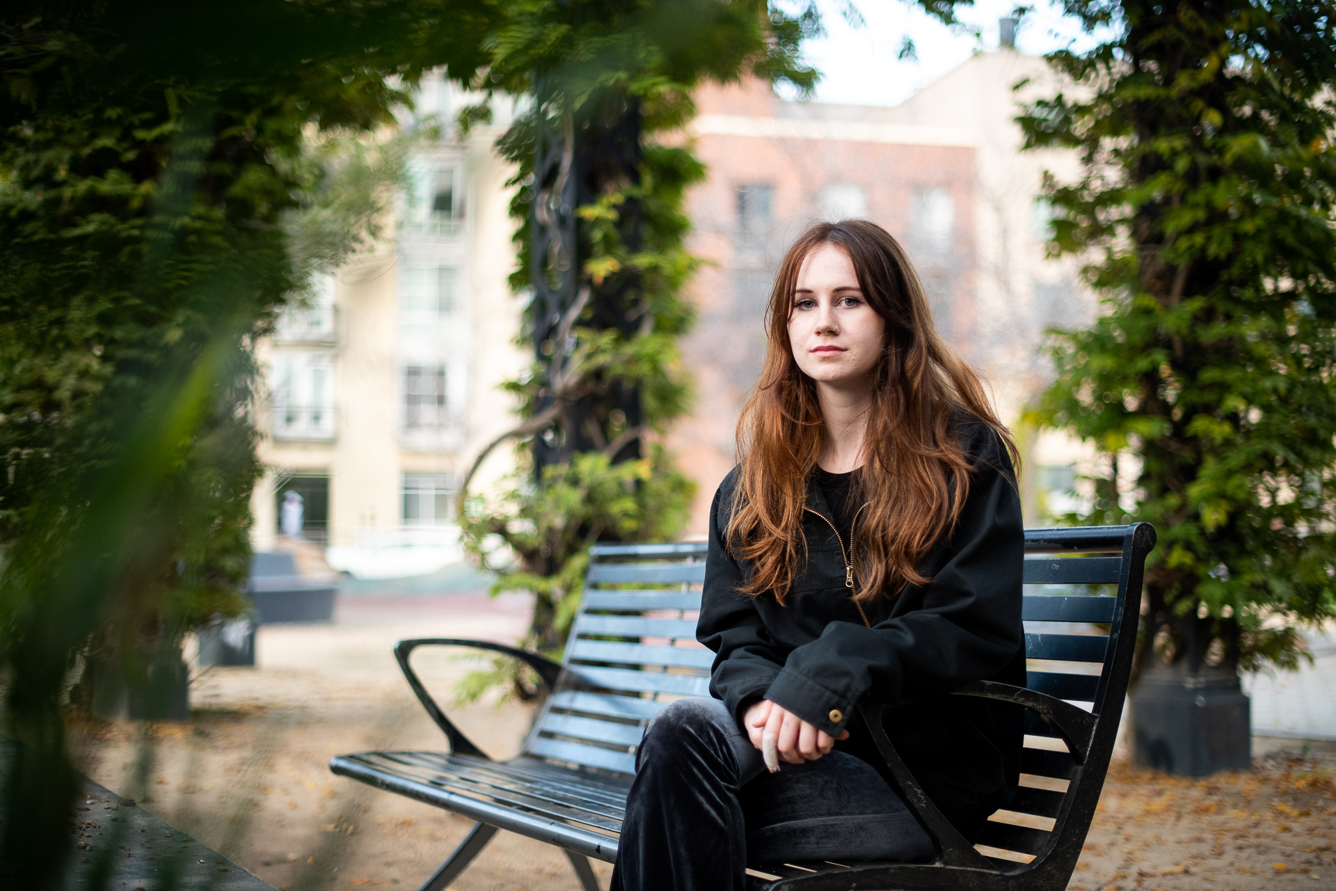 A girl sits on a park bench.