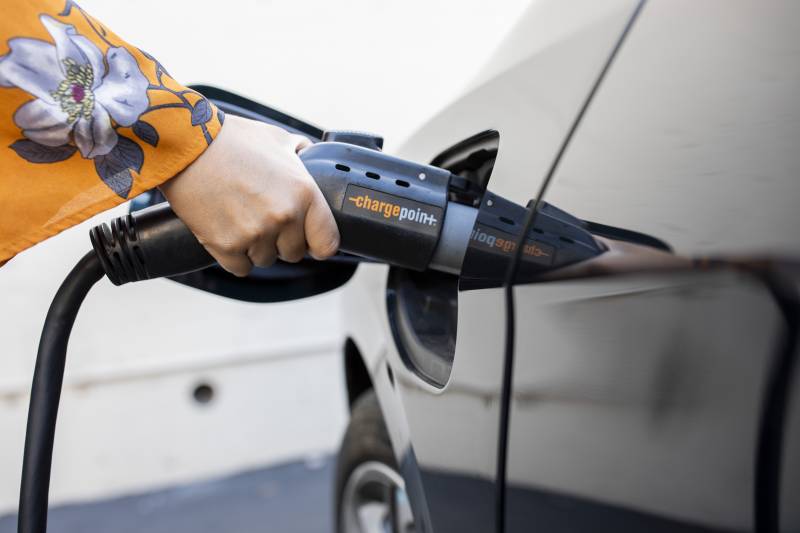a person fuels an electric car