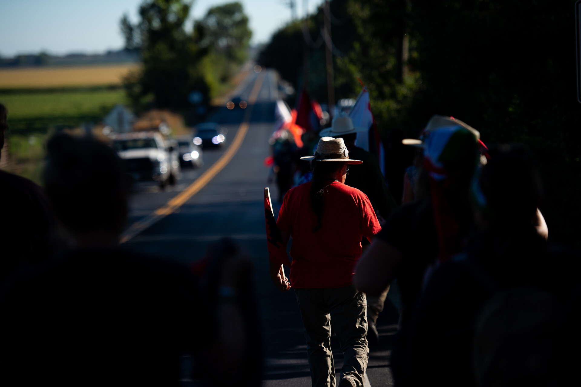 line of marchers walks down a rural highway