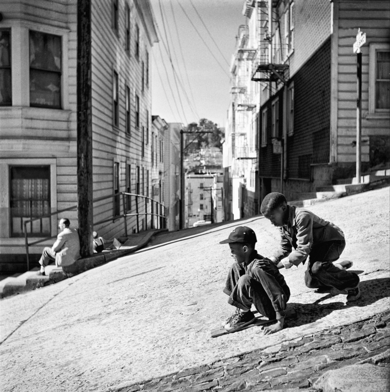 Two children slide down a steep street in San Francisco with cardboard boxes in 1952.