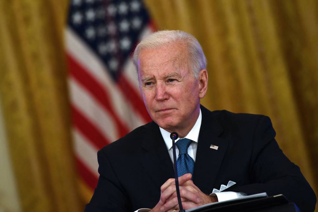 President Joe Biden sitting in front of a microphone.