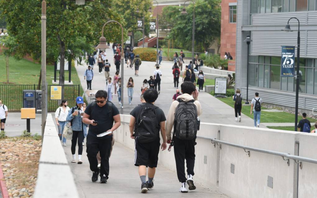 students walk with backpacks around a college campus