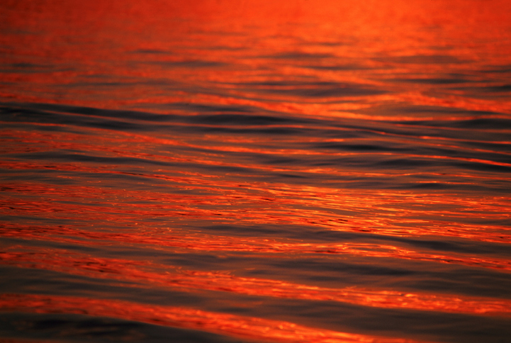 Red water with some ripples on the surface.