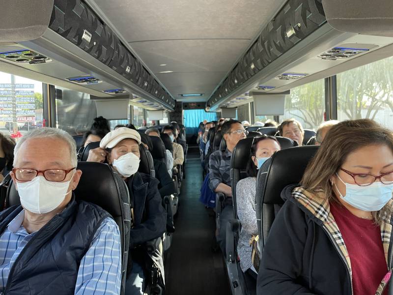 A bus with multiple people sitting in rows.