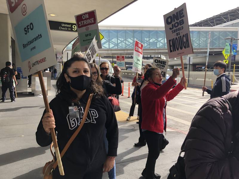 people striking with signs outside an airport