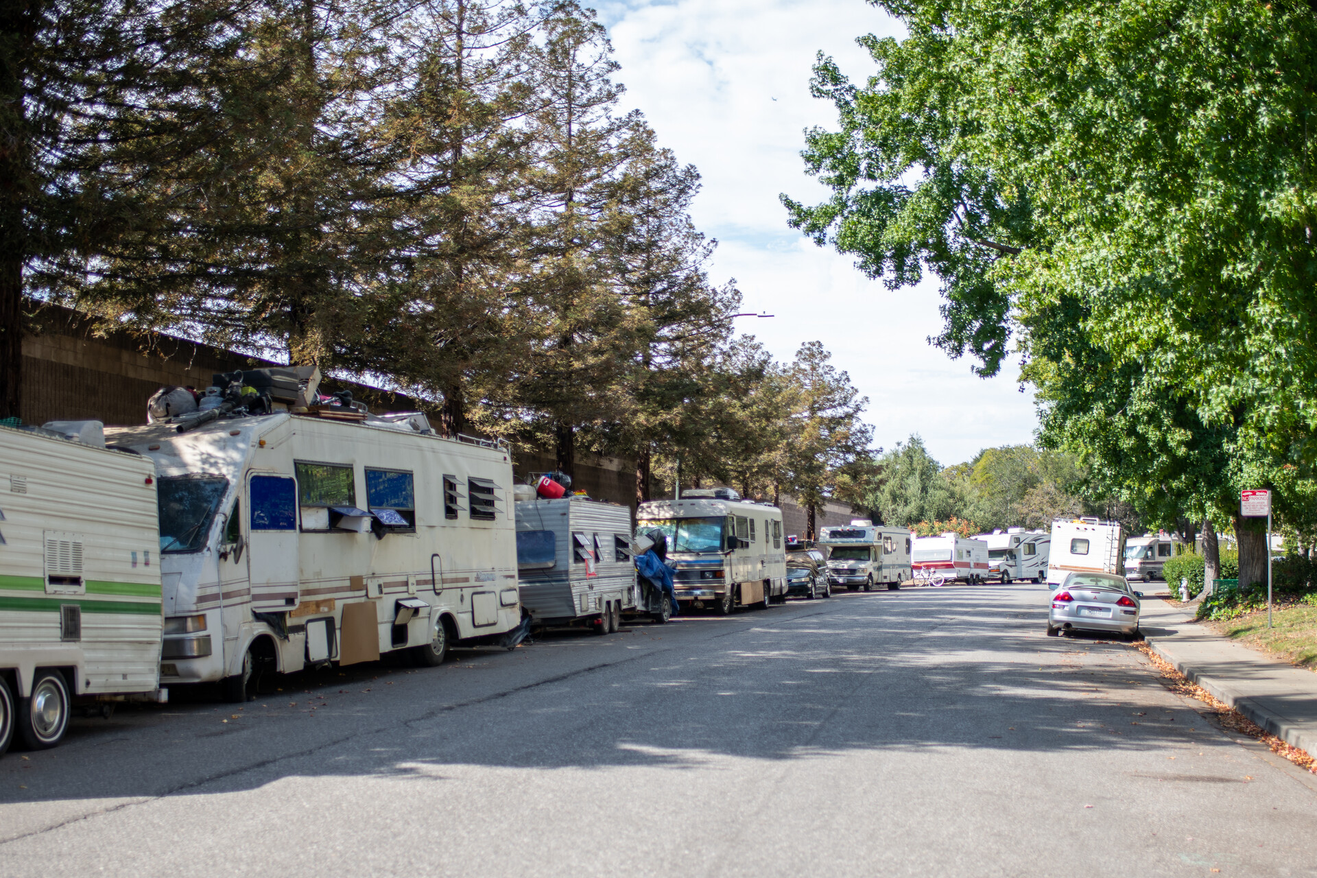 photo looking into the distance down a long street, with one side of the street completely lined with motorhomes