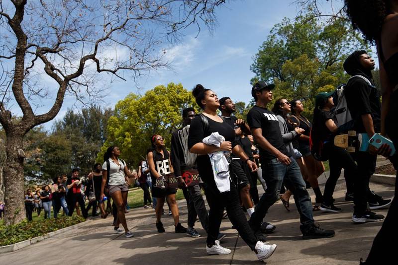 Black students march on a college campus during a protest