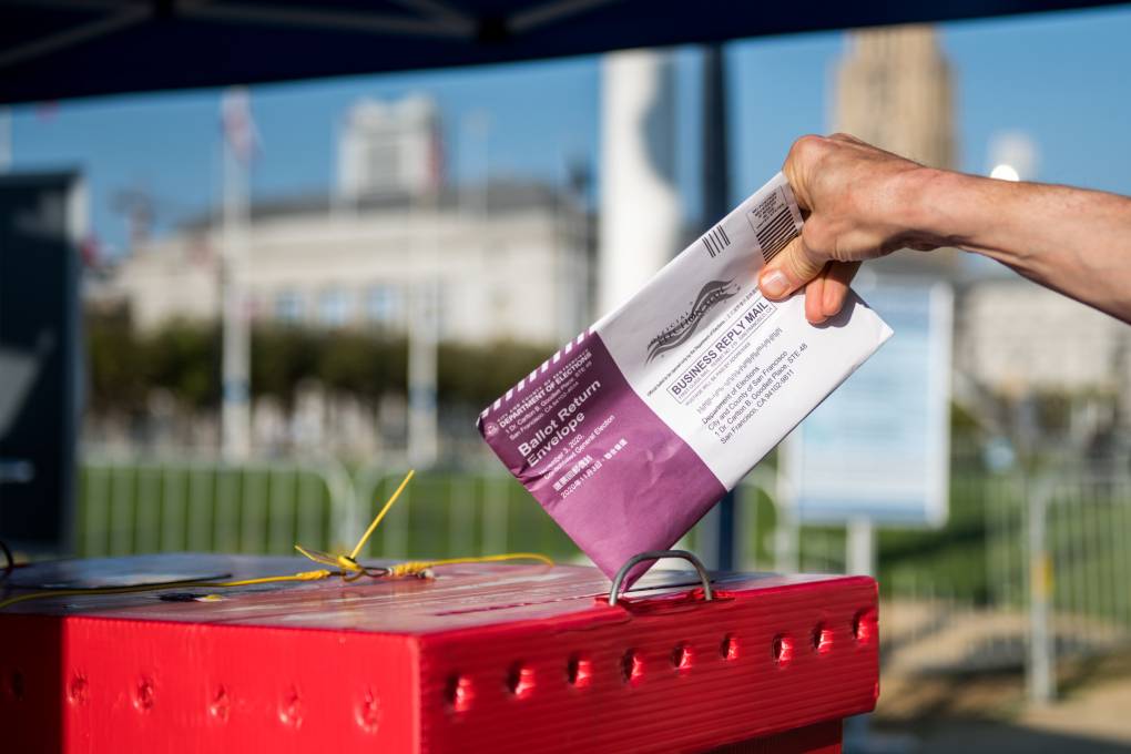 Un votante deja una papeleta en un nuevo centro de votación al aire libre cerca de Civic Center Plaza en San Francisco el 5 de octubre de 2020, el primer día de votación anticipada. Beth LaBerge/KQED