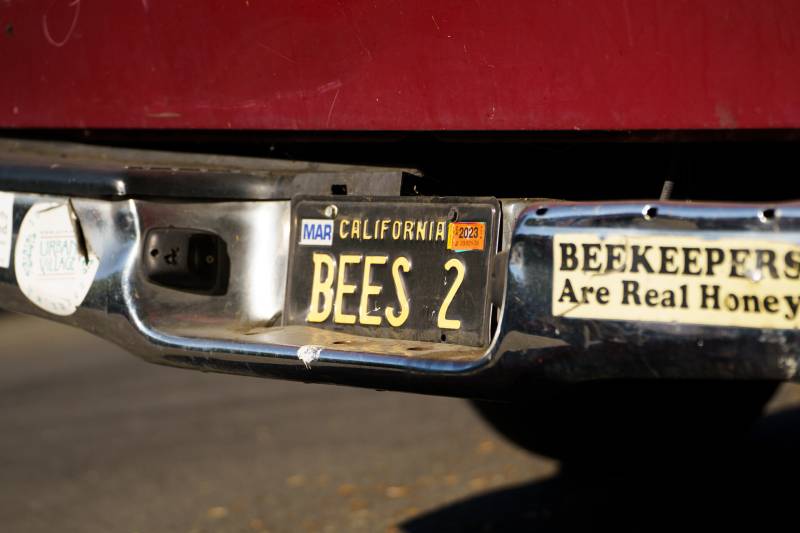 a license plate that reads 'Bees 2' and a bumper sticker that reads 'beekeepers are real honey'