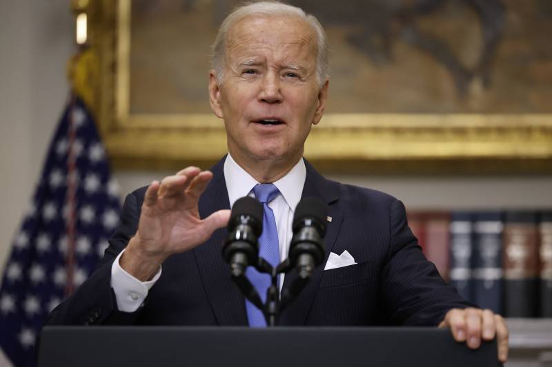 President Joe Biden speaks into a microphone at a podium.