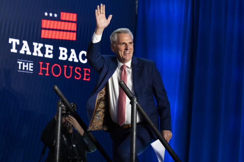 Kevin McCarthy waves on a stage