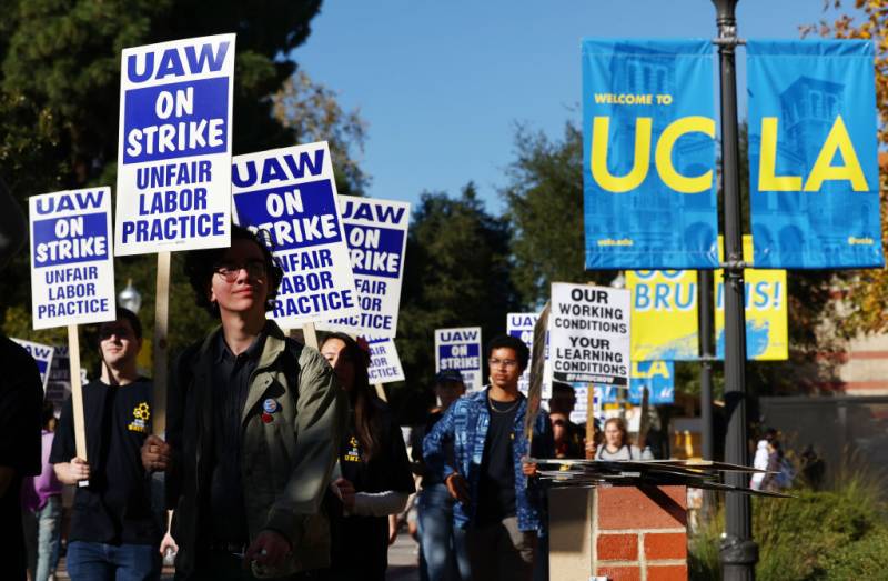 a labor strike at UCLA, with people marching and holding signs