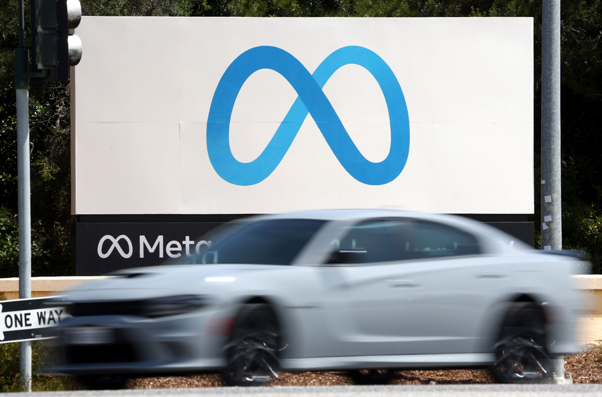 Blue infinity symbol on white sign with car zooming by