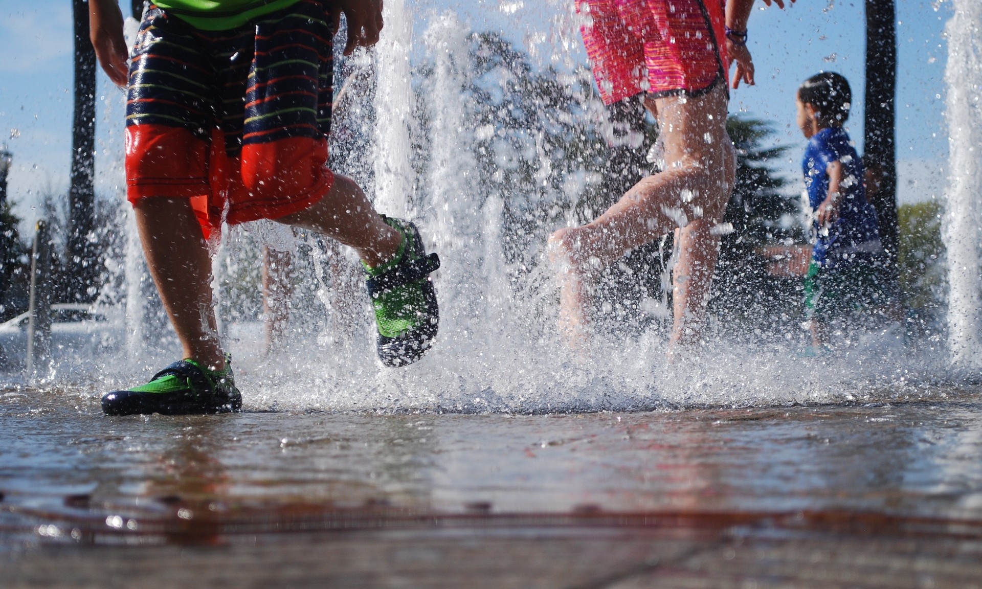 Kids splashing around in an outdoor splash pad.