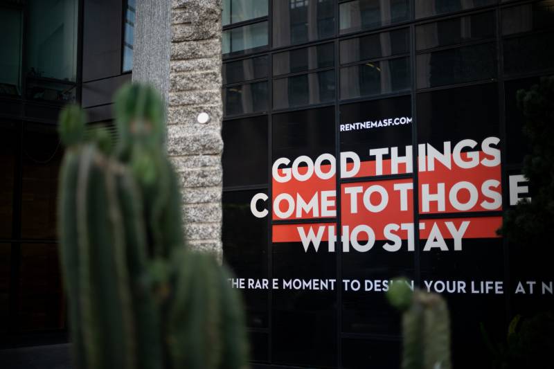 a sign that says 'good things come to those who stay' on an apartment building