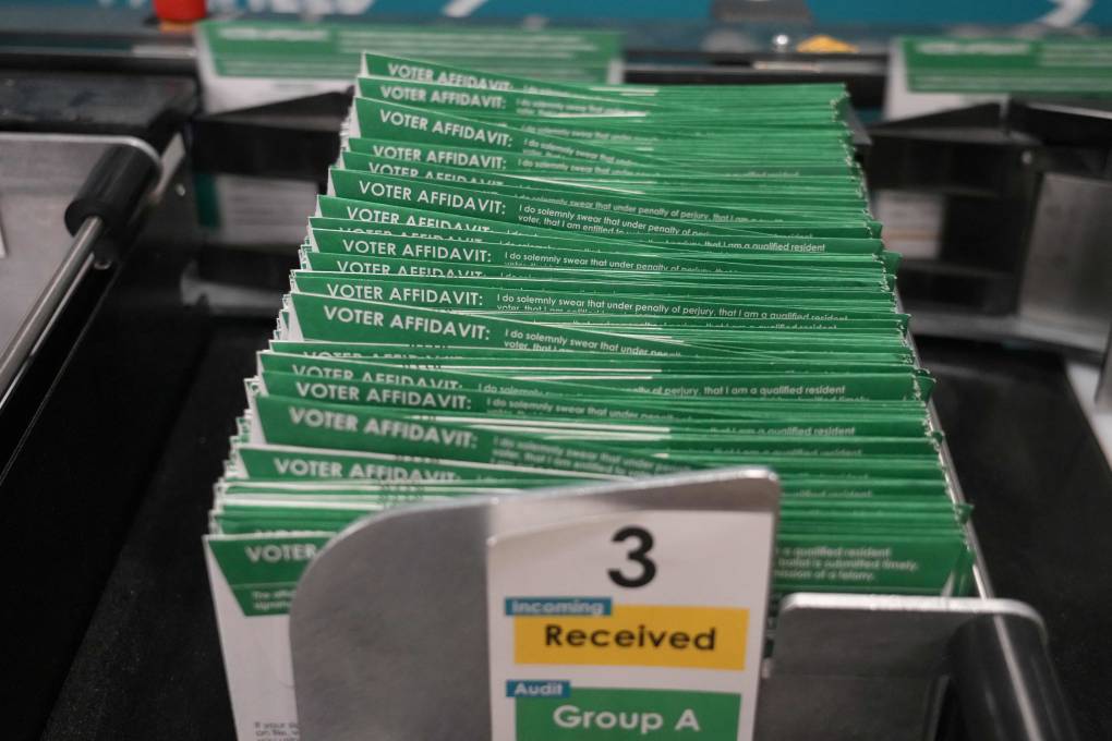 A stack of green and white envelopes on a table.