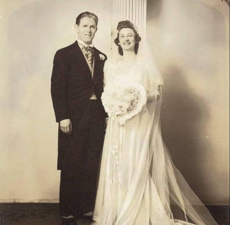 A vintage photo of a man wearing a suit and woman wearing a white wedding dress.