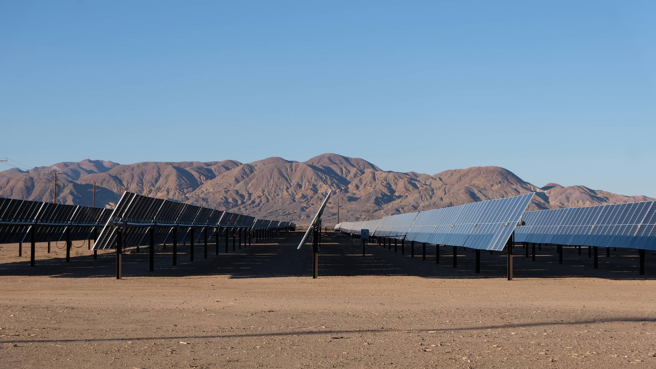 solar panels are seen in the desert in front of a mountain range