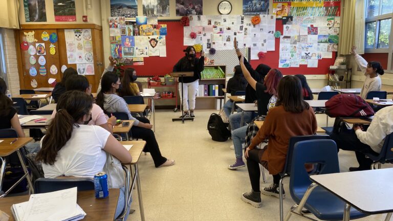 A classroom with female Latina teacher and students.