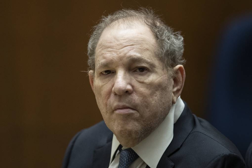 an older balding man frowns in a suit in court
