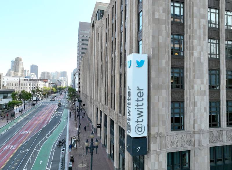 An aerial view of a sign on a building that reads "@twitter" with a blue bird logo.