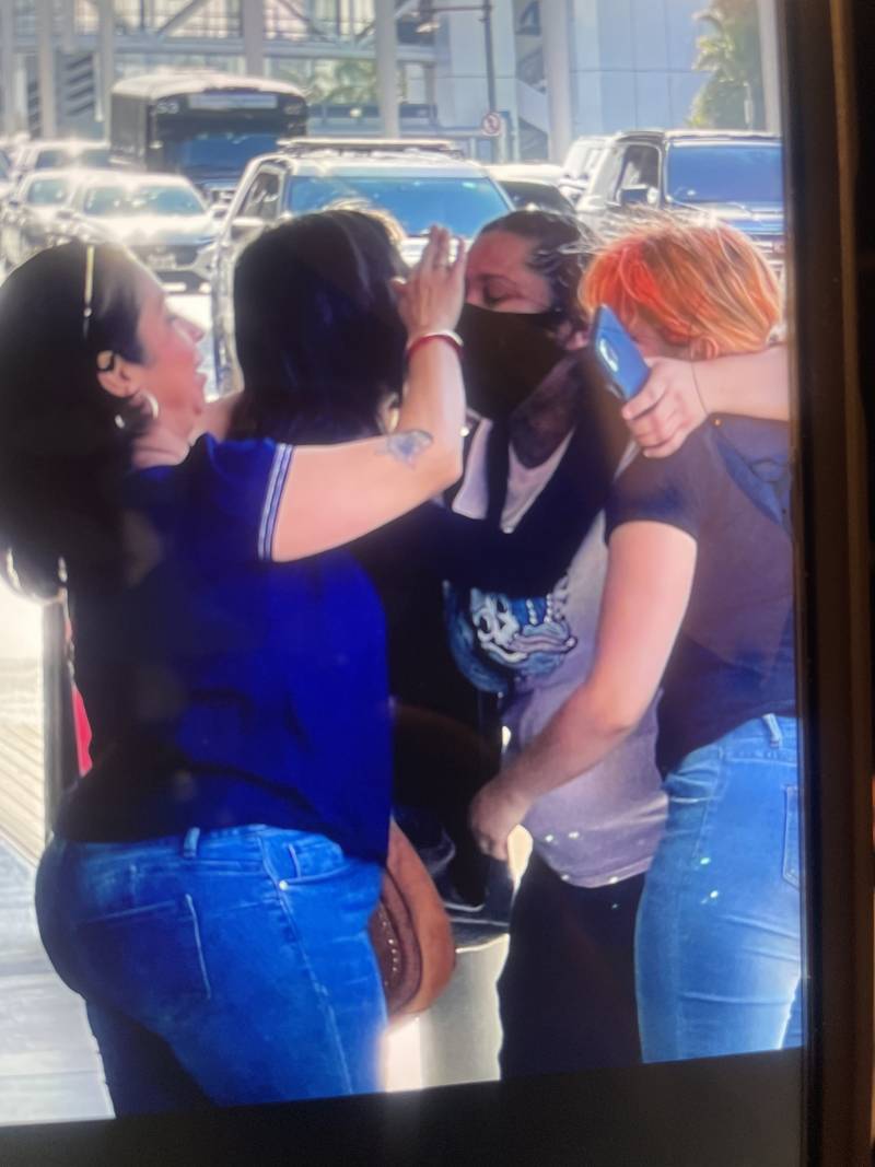 Four women hug at the airport.
