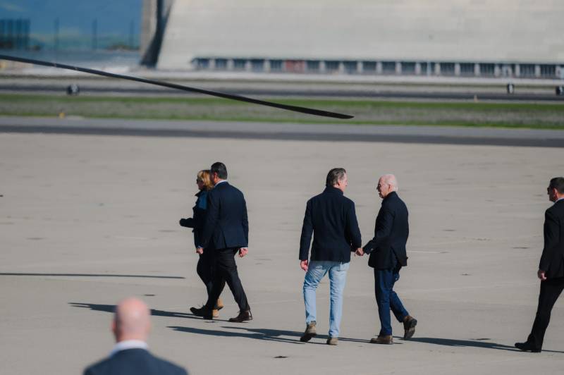 Four men are seen walking across an airfield.