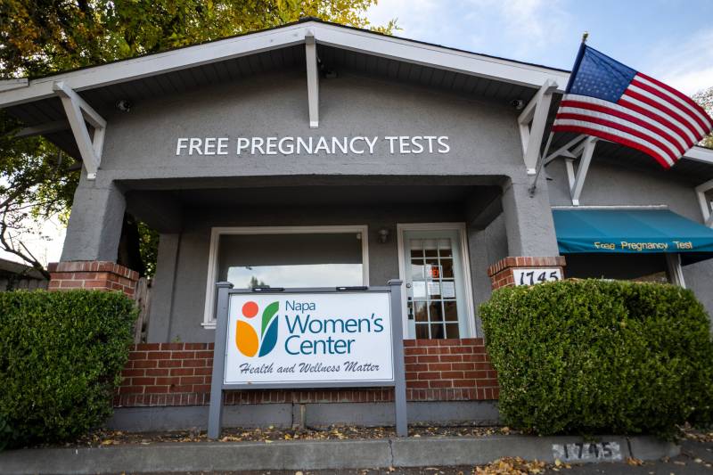 a gray building with words that say 'free pregnancy tests' and 'Napa Women's Center, health and wellness matter'