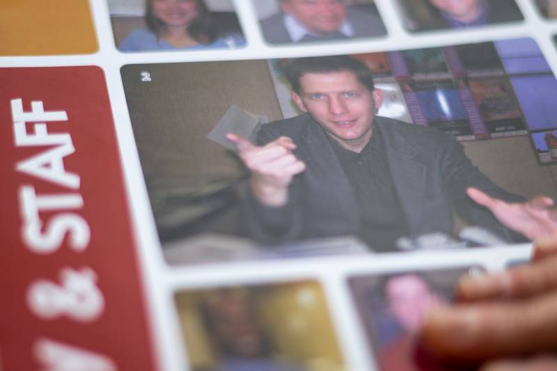 a yearbook photo shows a white male teacher smiling and pointing